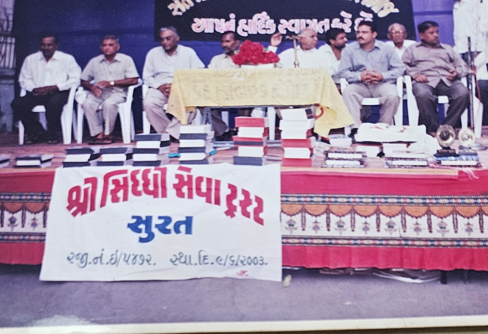 A book distribution programme with guests on stage and the Trust's banner in front