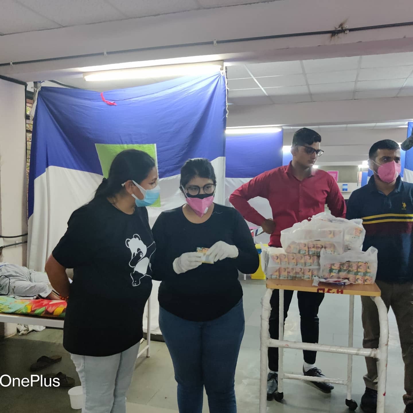 Volunteers preparing packets of juice and supplies for patients at a COVID care centre