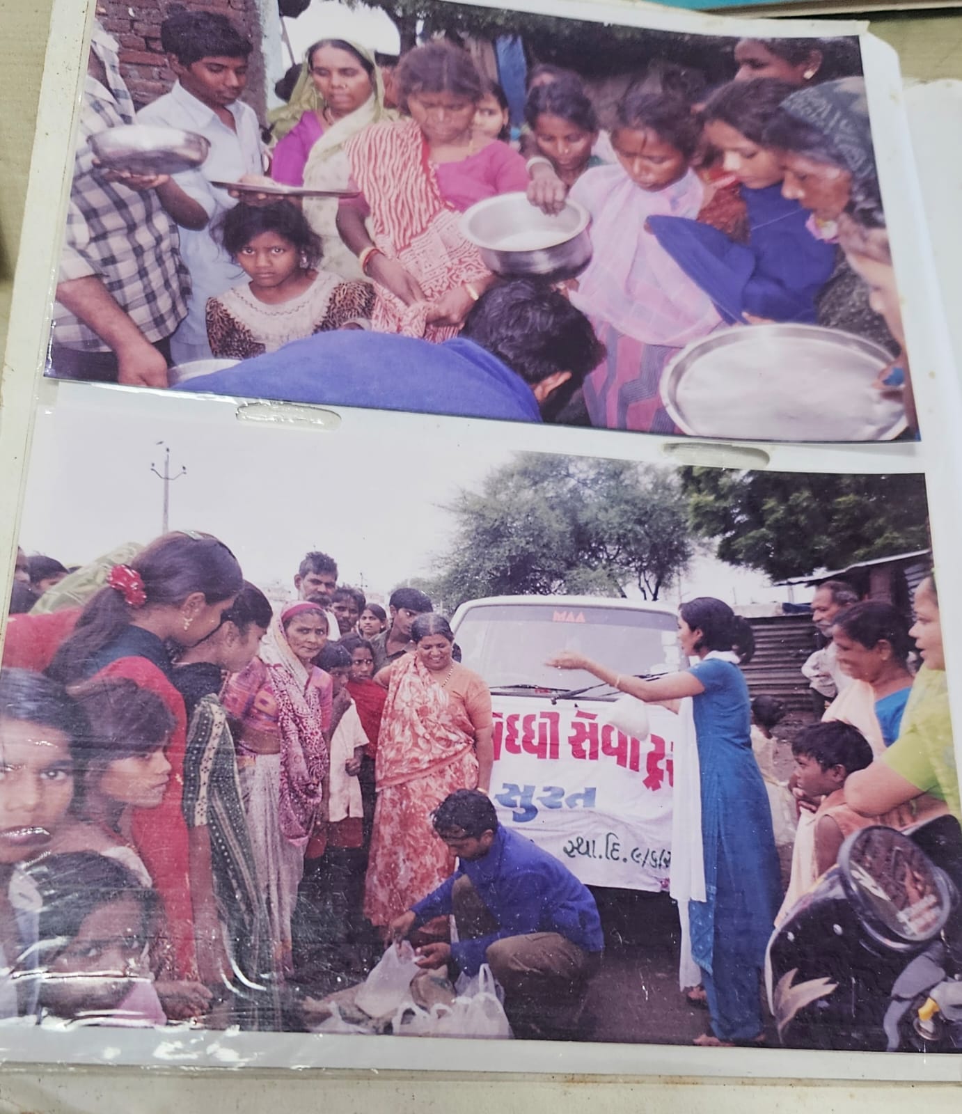 Residents waiting with plates and vessels as volunteers serve food during relief work
